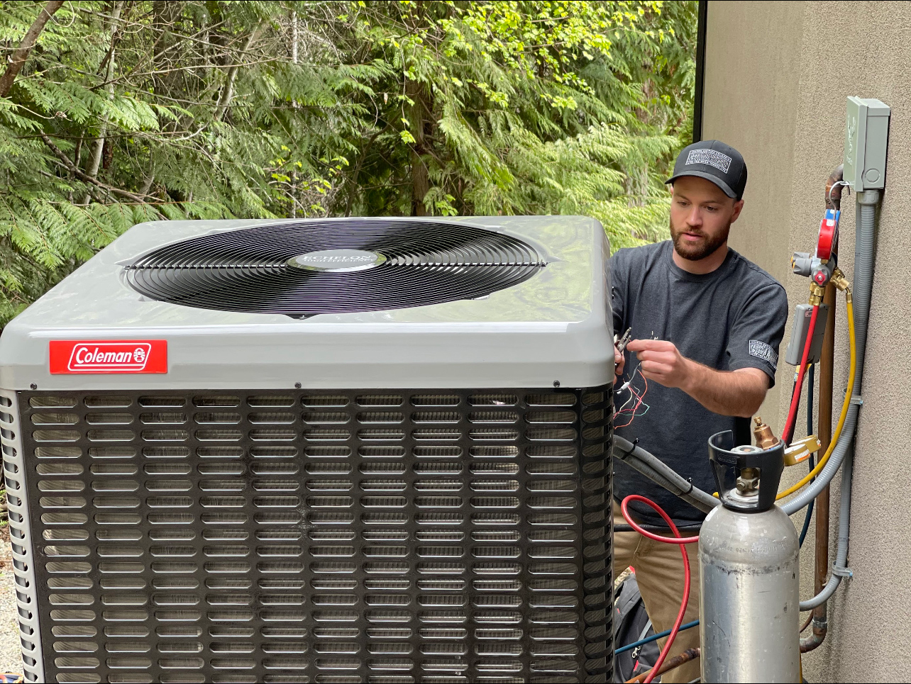 A man is testing and repairing an air conditioner outside.
