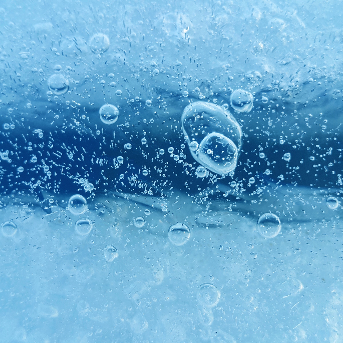 Ice surface with frozen air bubbles, close-up natural texture, ice pattern winter background