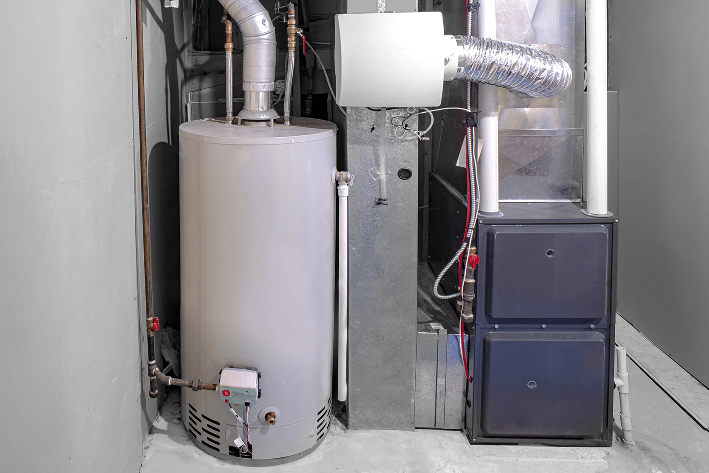 A gas water heater next to a furnace in a utility room, labeled as "Hot Water Tank."